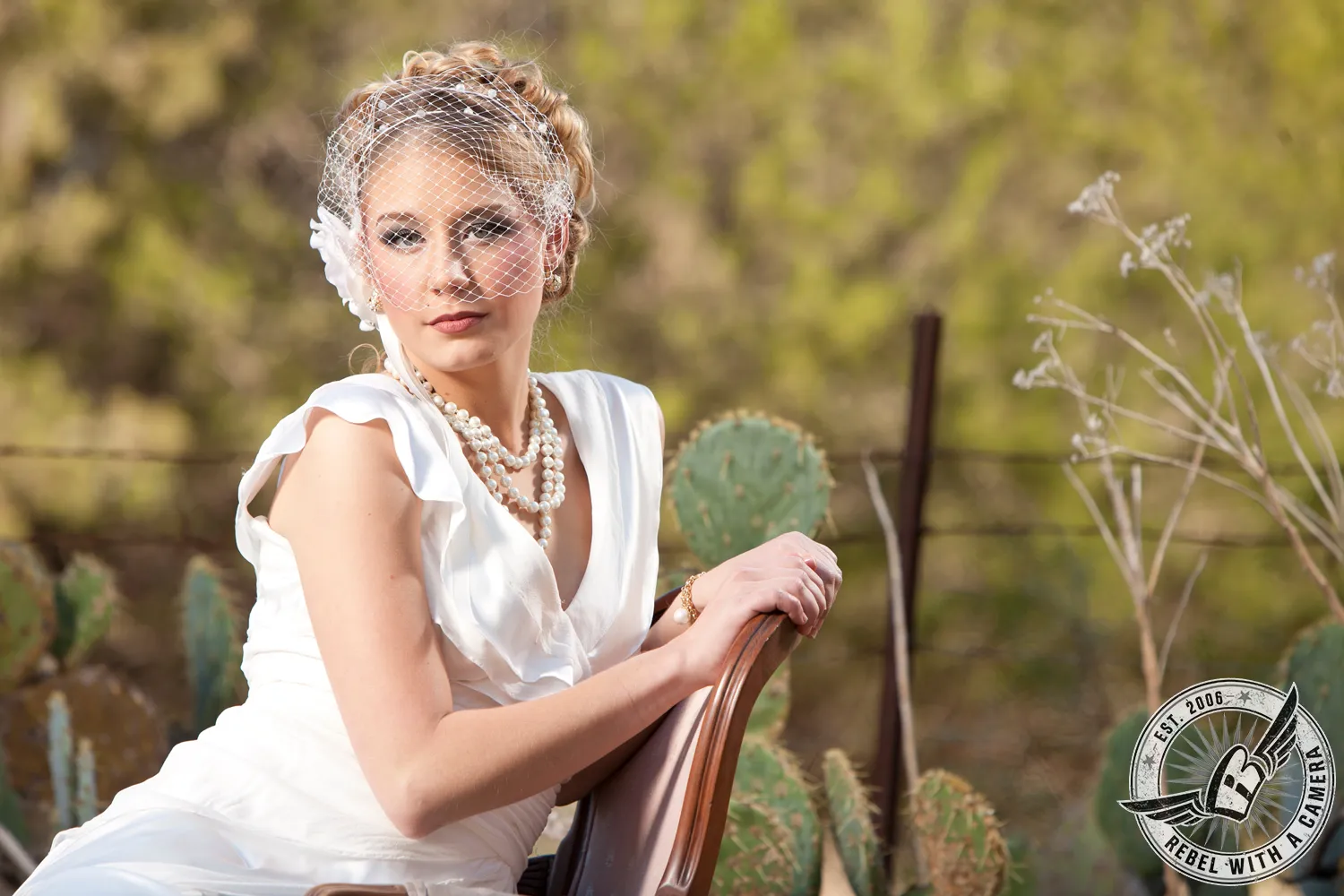 Bride in a white dress and birdcage veil seated outdoors in Austin, Texas.
