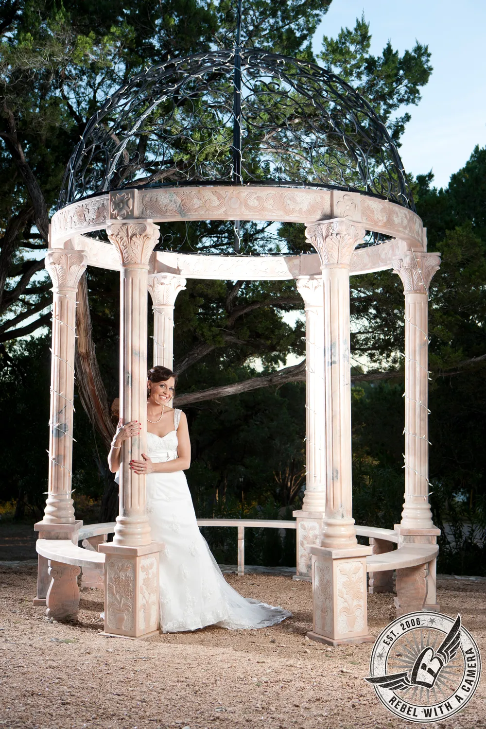 Bride standing inside an ornate garden gazebo