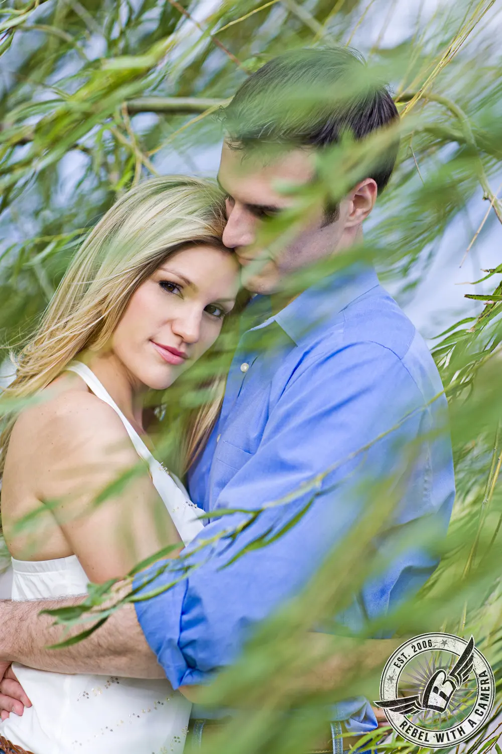 Couple embracing and kissing among leafy branches