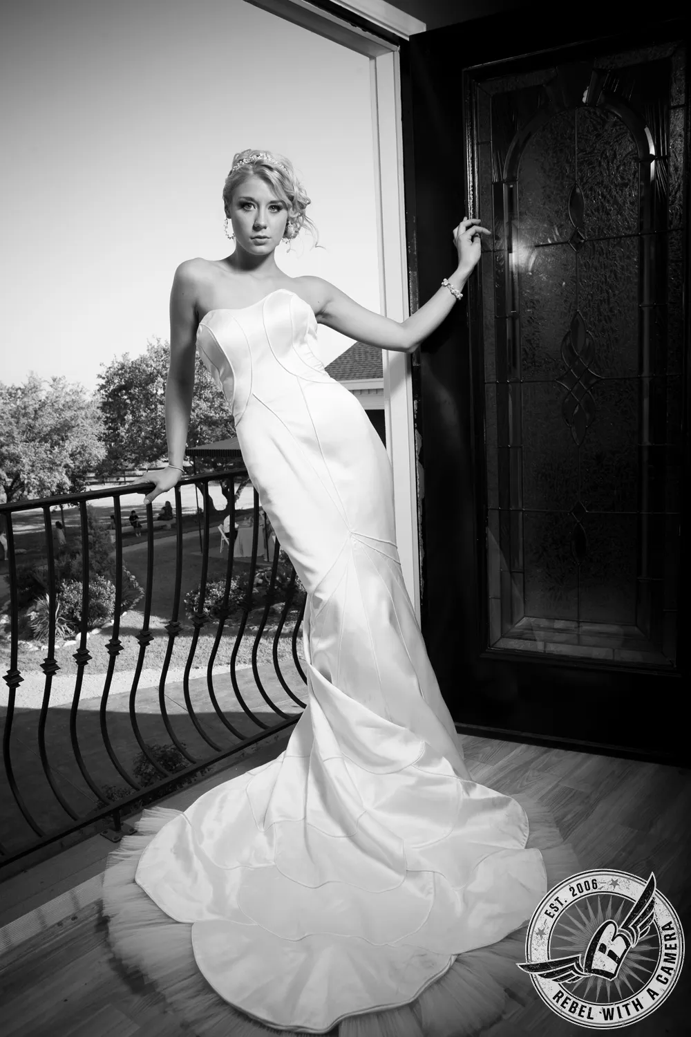 Black and white bride standing on a balcony beside an open door in Austin, TX.