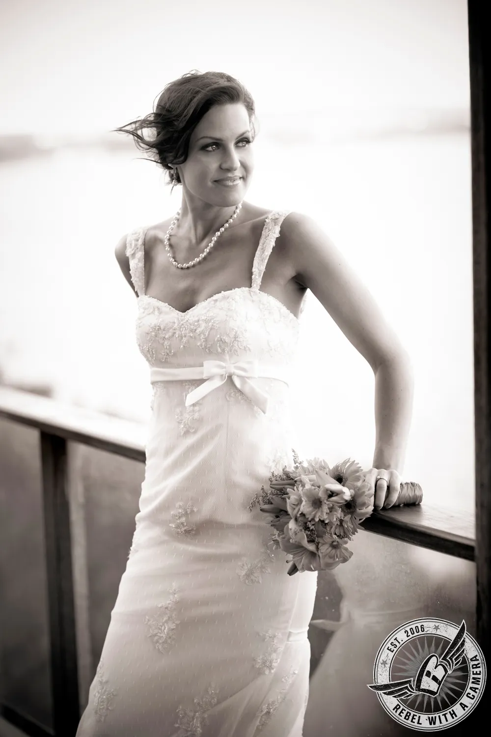 Black and white bride holding a bouquet beside a bright window in Austin, TX.