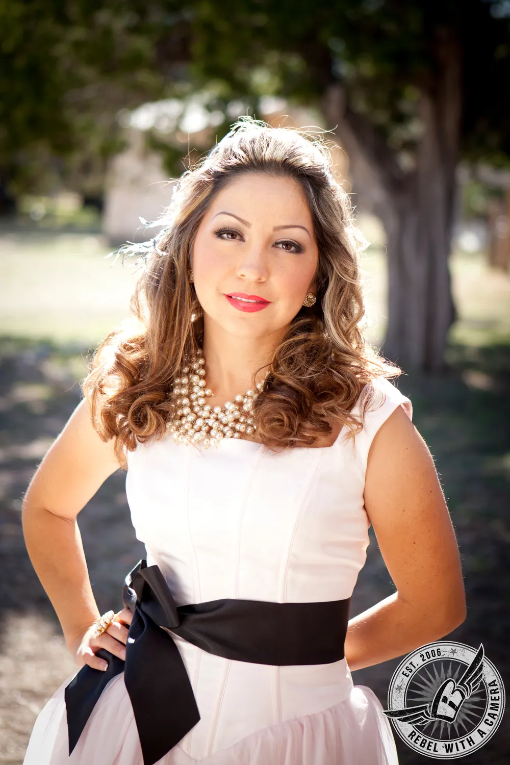 Portrait of a woman in a white dress and layered pearl necklace in Austin, TX.