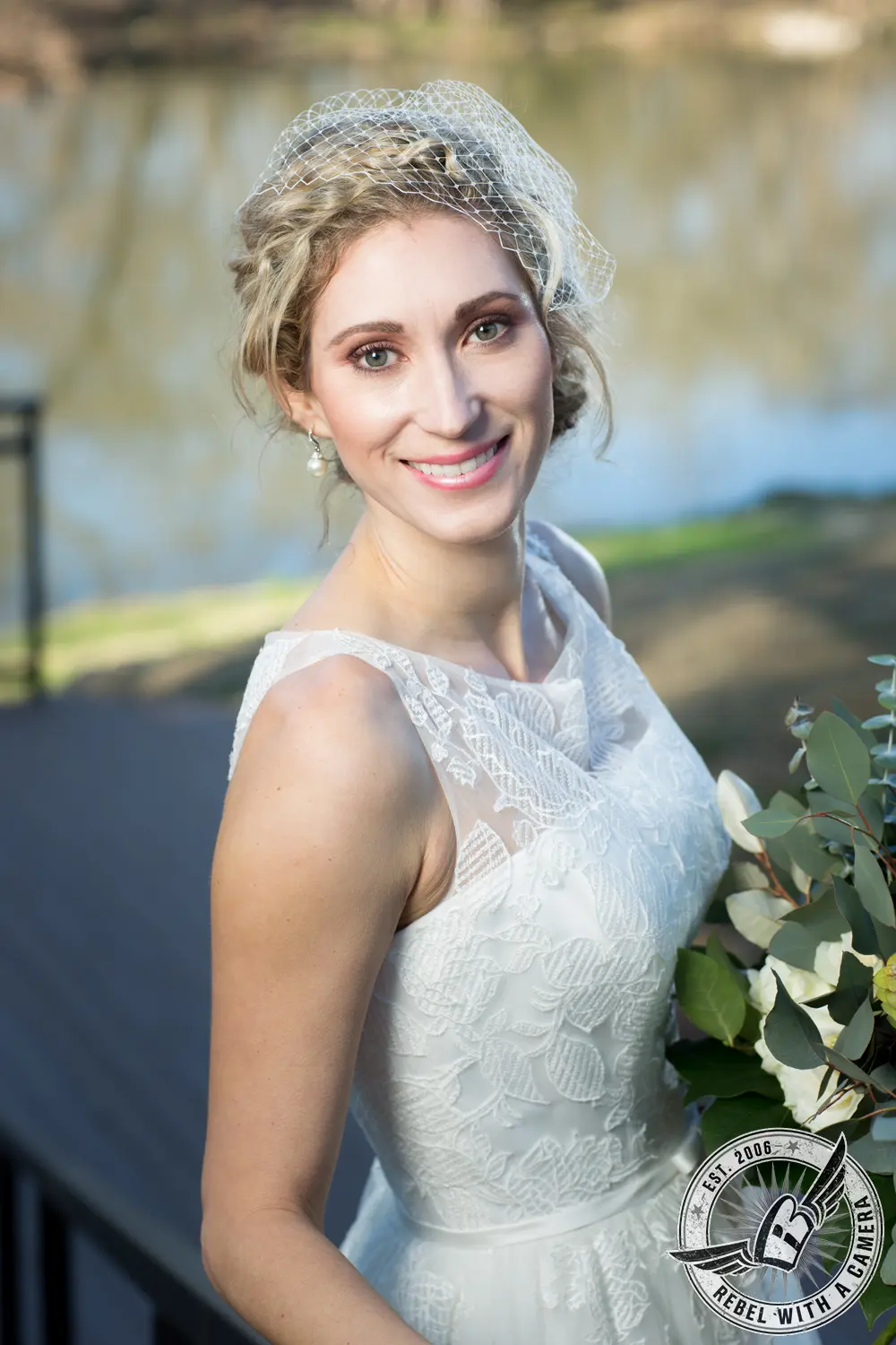 Bride in a white lace gown and birdcage veil holding eucalyptus greenery in Austin, TX.