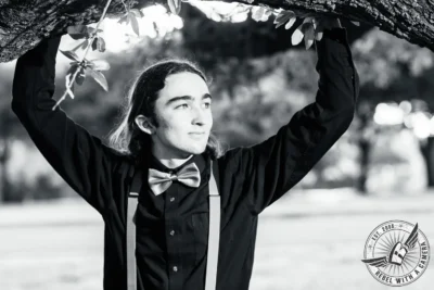 Black and white Alexander senior portrait beneath a tree branch in Austin, TX.