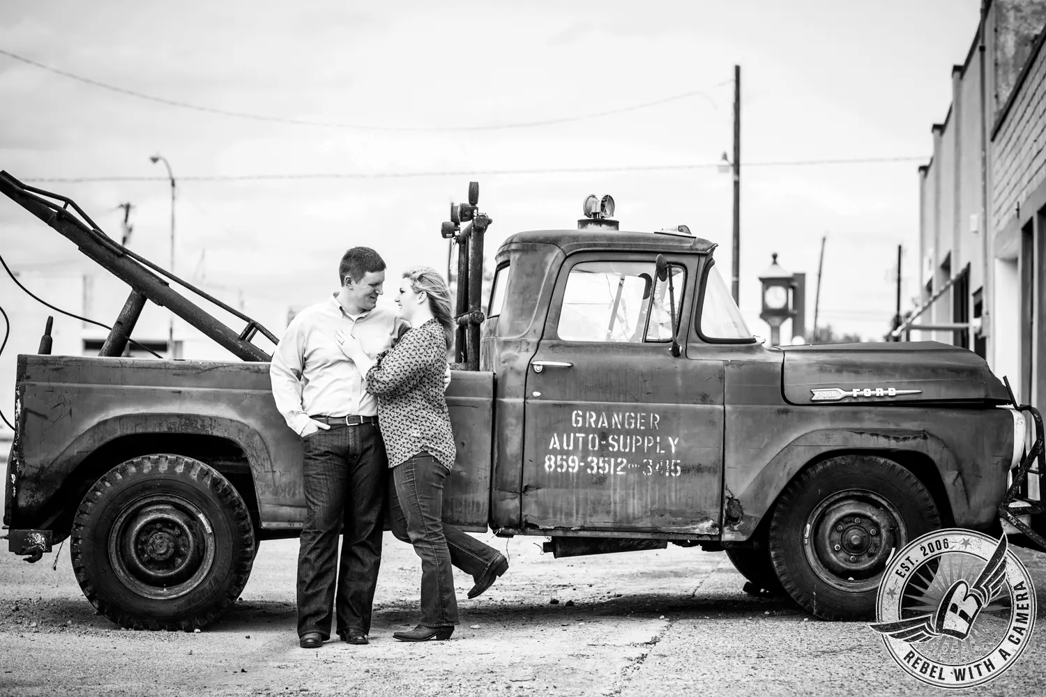 Black and white couple posing beside a vintage tow truck in Austin, TX.
