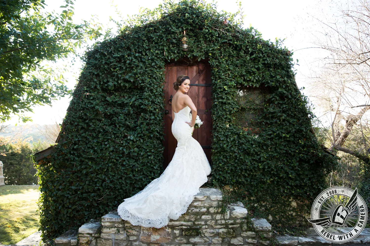 Bride in a white wedding dress posing in front of a leafy doorway in Austin, Texas.