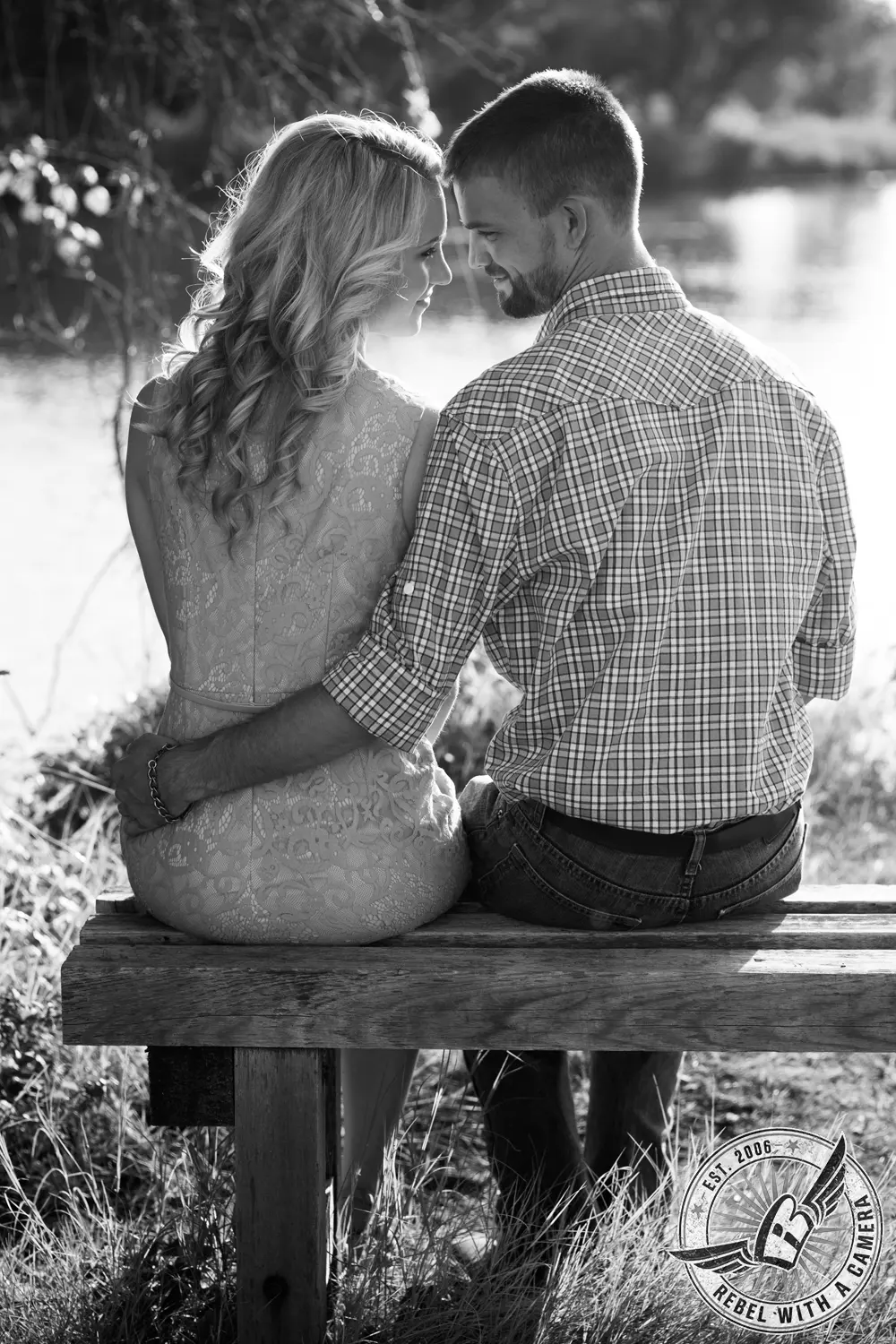 Black and white couple sitting together on a wooden bench beside a lake in Austin, TX.