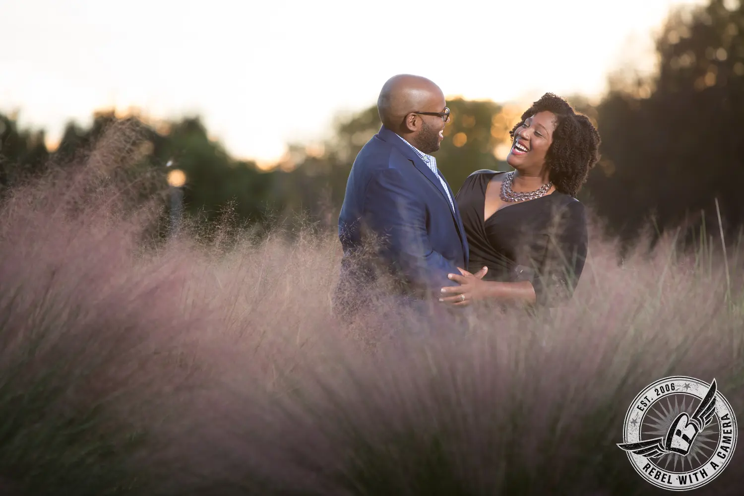 Couple laughing together in a field of ornamental grass at sunset in Austin, TX.