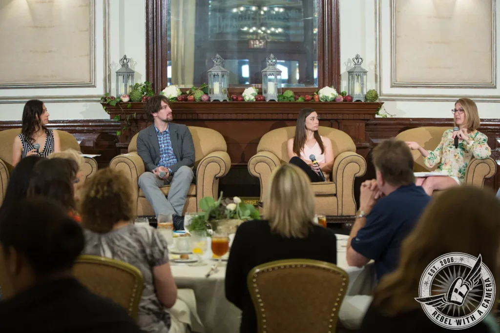 Panel discussion with four speakers and an audience in Austin, TX.