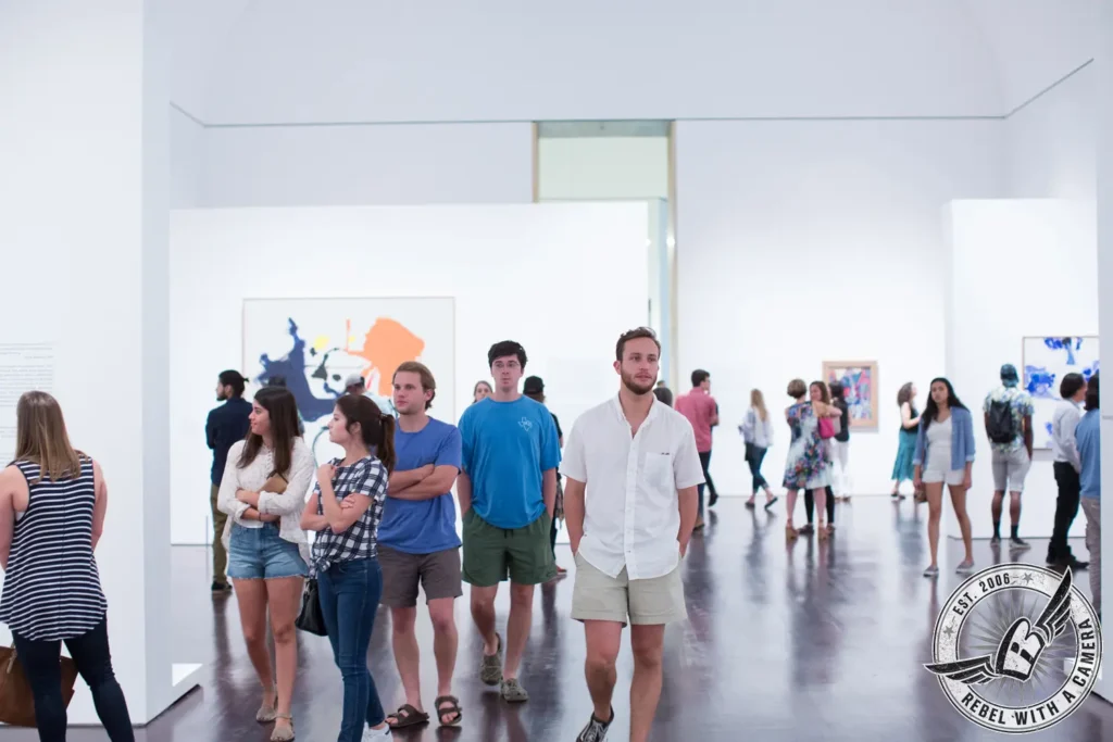 Visitors viewing art in a bright museum gallery in Austin, TX.
