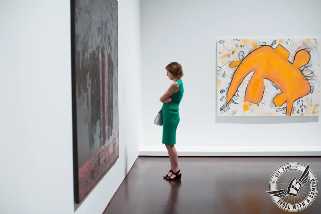 Museum visitor viewing large contemporary paintings in Austin, TX.