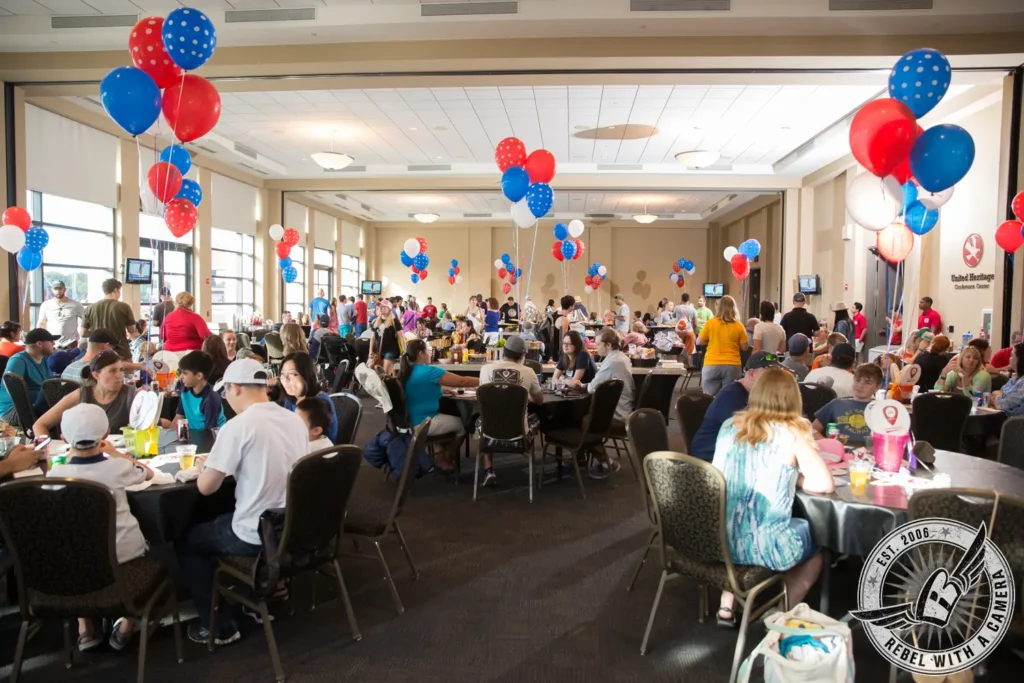 Crowded Austin Summerfest event room decorated with red white and blue balloons in Austin, TX.