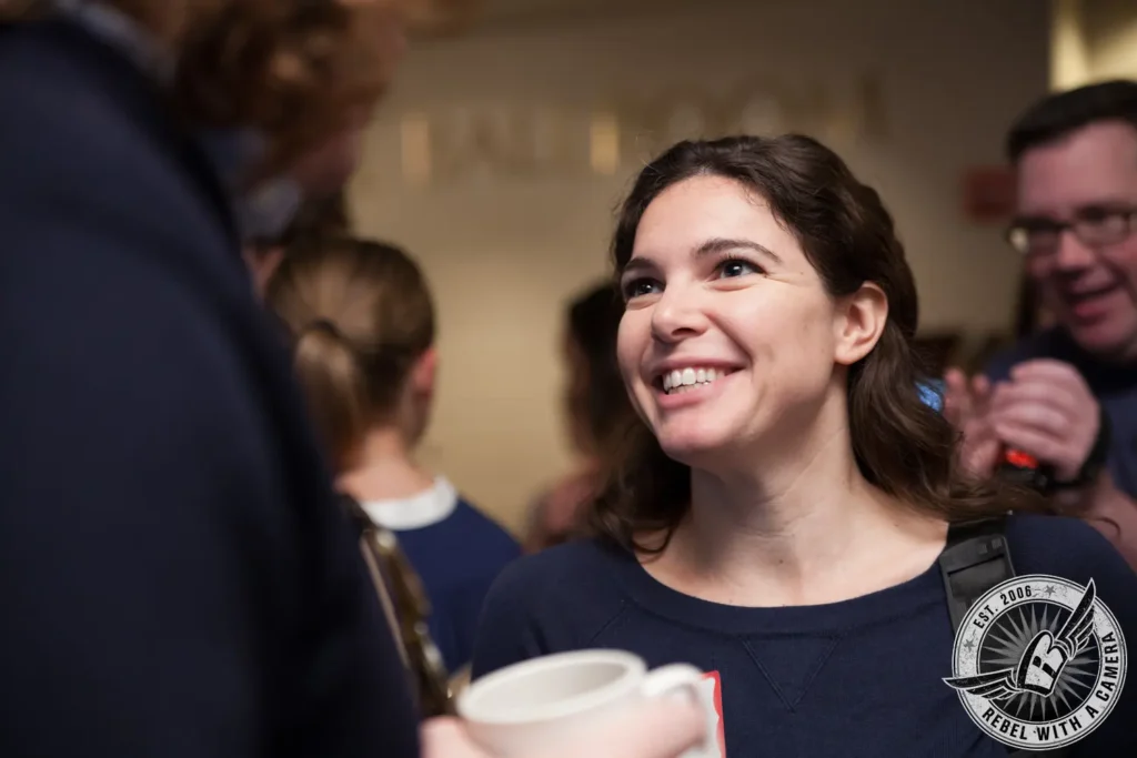 Smiling woman talking with guests at a corporate event in Austin, TX.