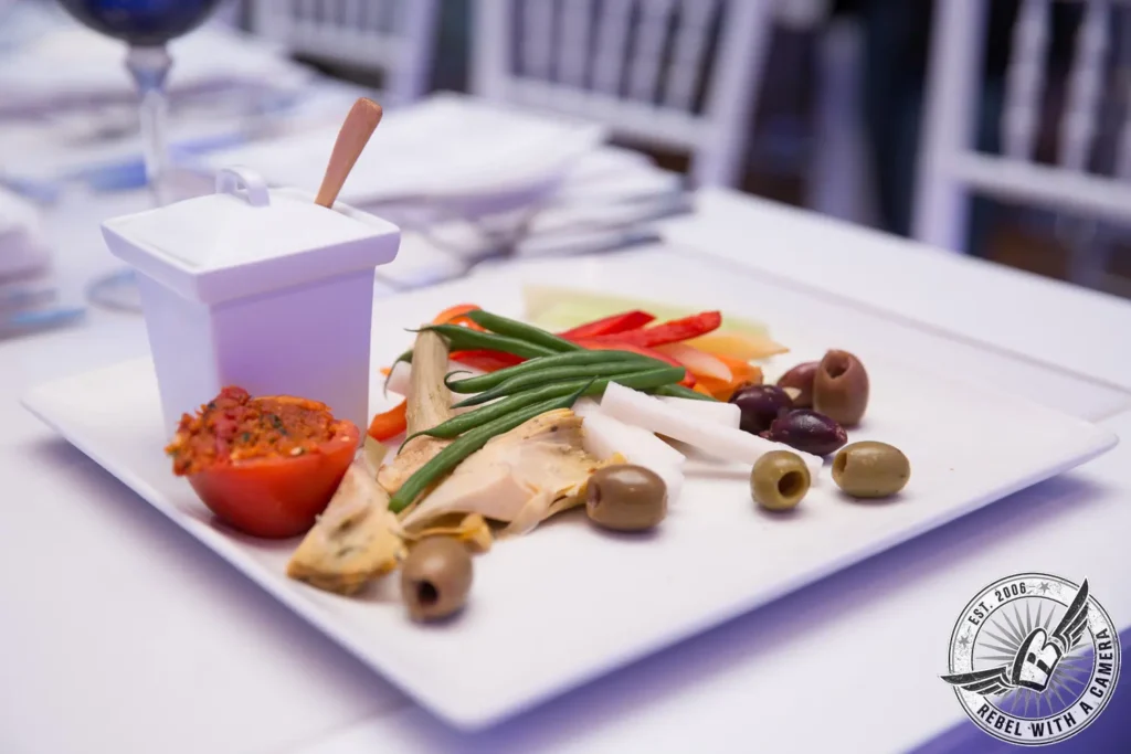 Plated vegetables, olives, and spread at an event in Austin, TX.