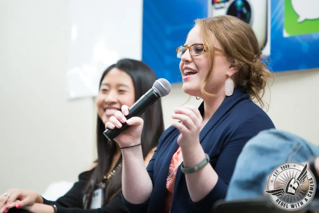 Woman speaking into a microphone during a panel discussion in Austin, TX.