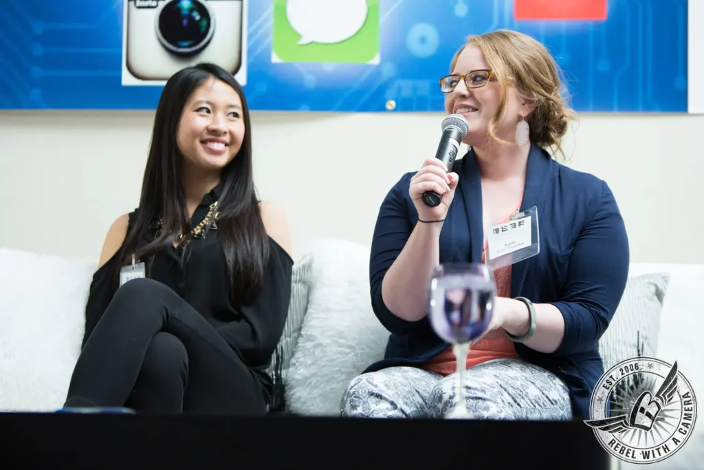 Two women participating in a panel discussion with microphones