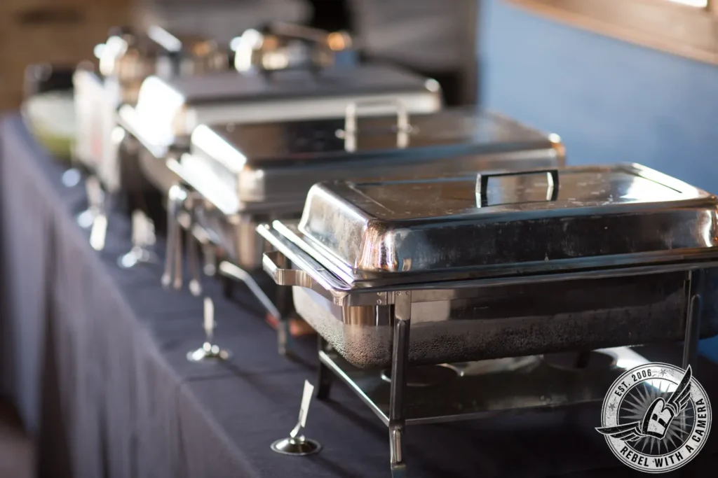 Stainless steel chafing dishes set up for a corporate event buffet in Austin, TX.