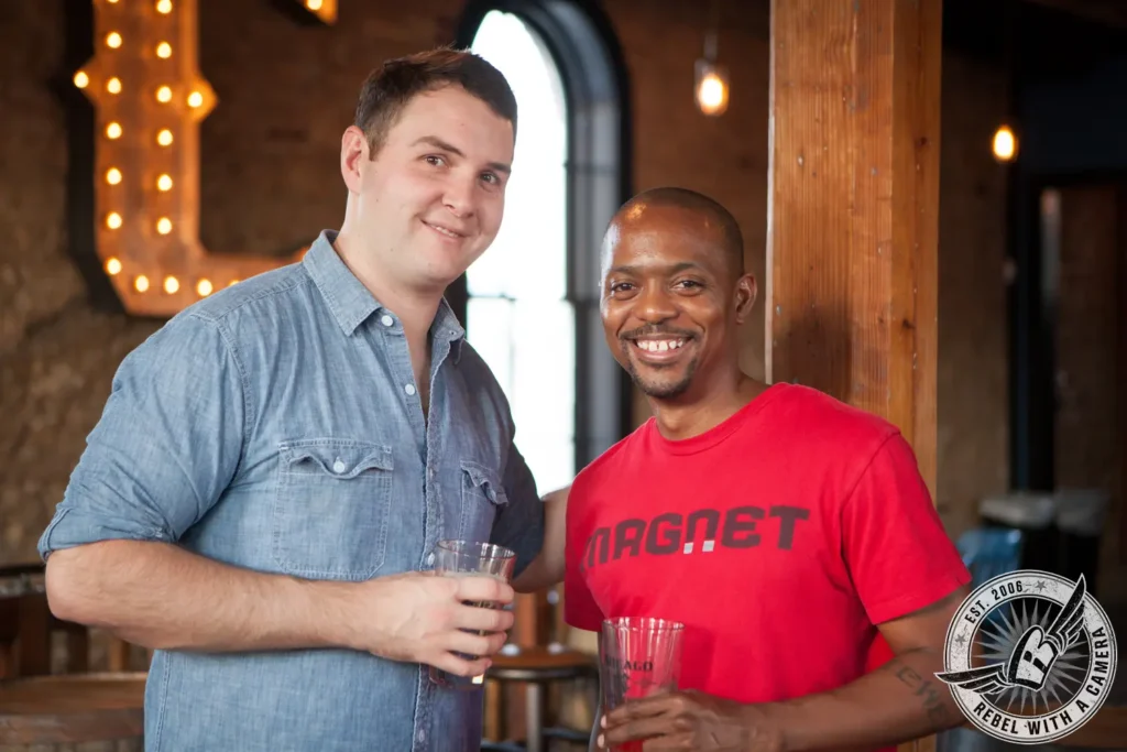 Two smiling men holding drinks at a corporate event in Austin, TX.