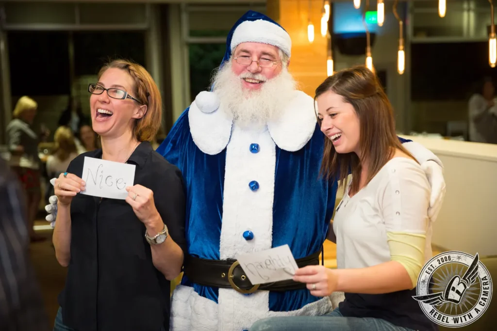 Santa posing with two women holding Nice and Naughty signs in Austin, TX.