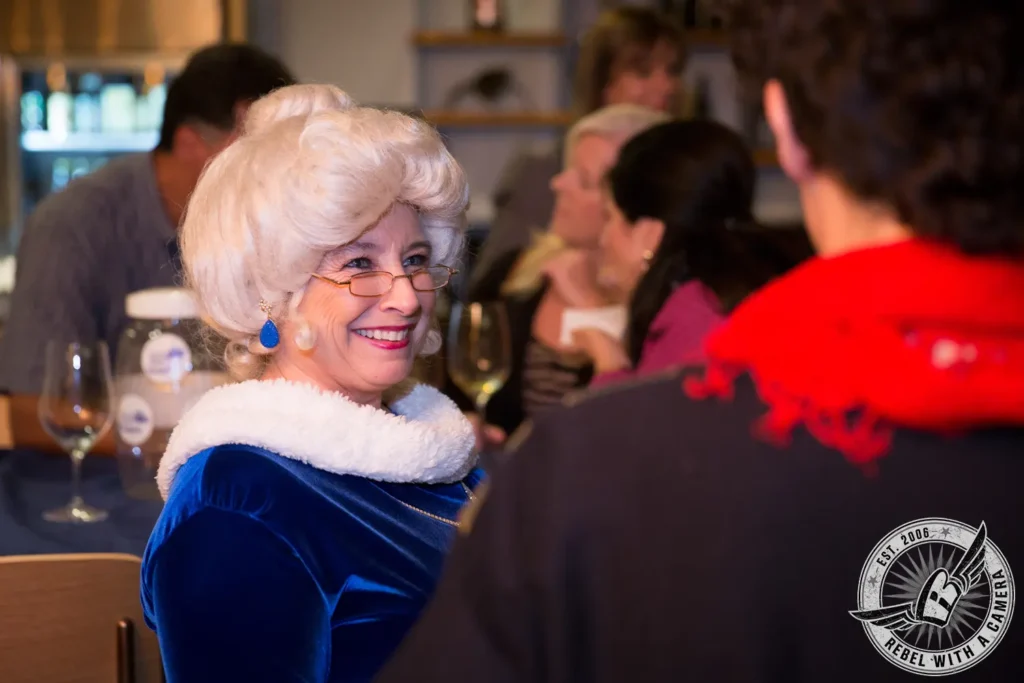 Smiling older woman in a blue velvet jacket at an event in Austin, TX.