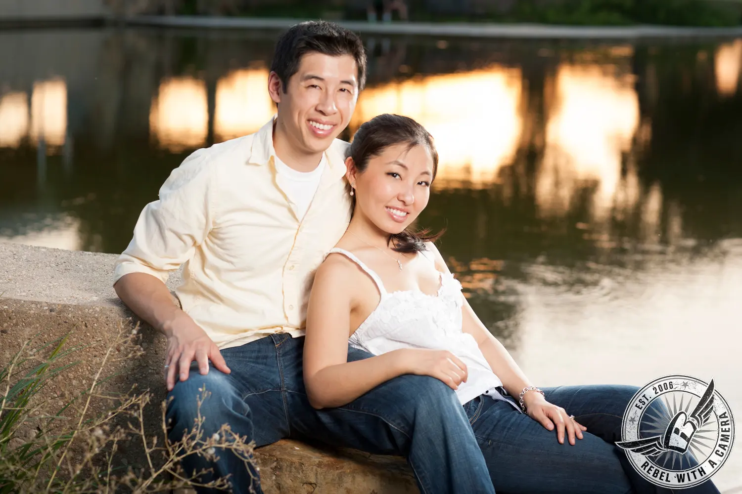 Couple sitting beside a lake at sunset