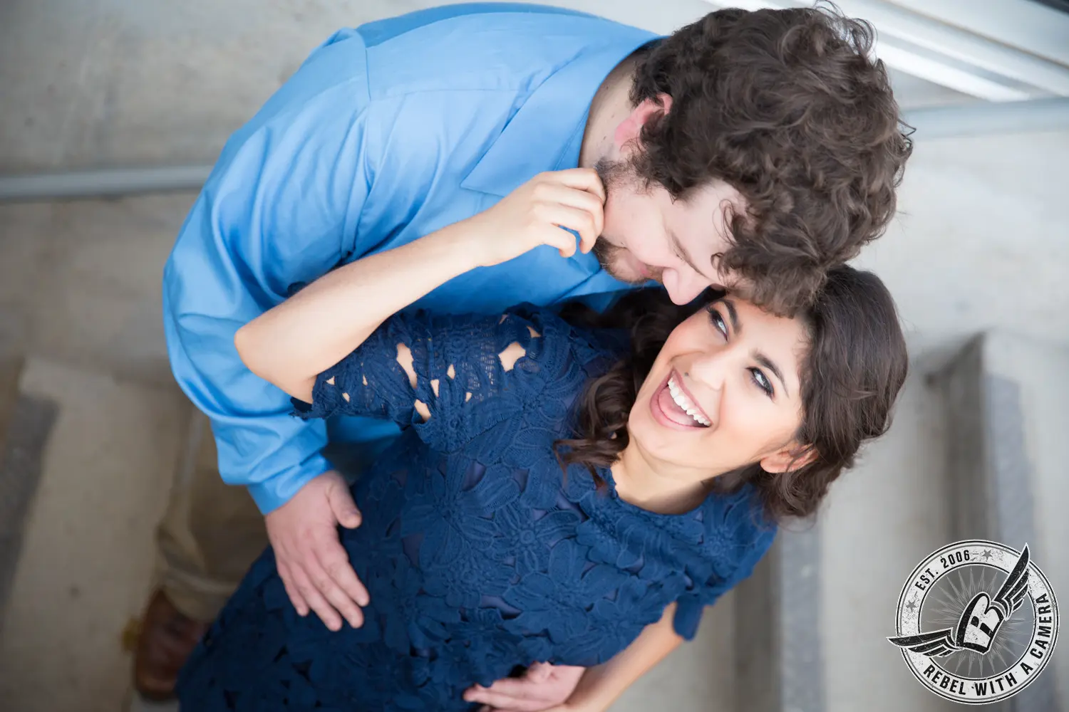 Couple embracing and smiling in a blue room photographed from above in Austin, TX.
