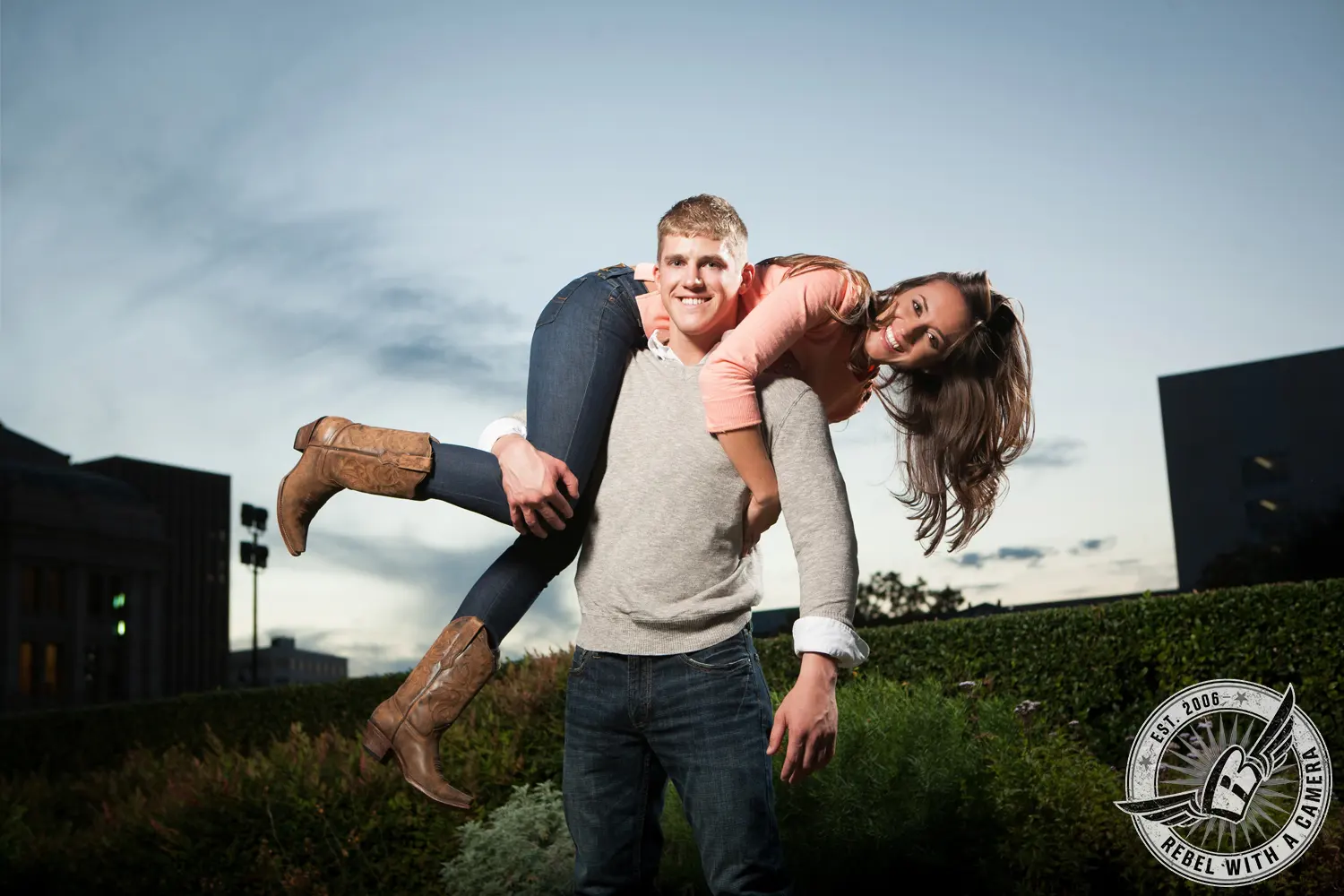 Man carrying a woman over his shoulders outdoors in Austin, TX.