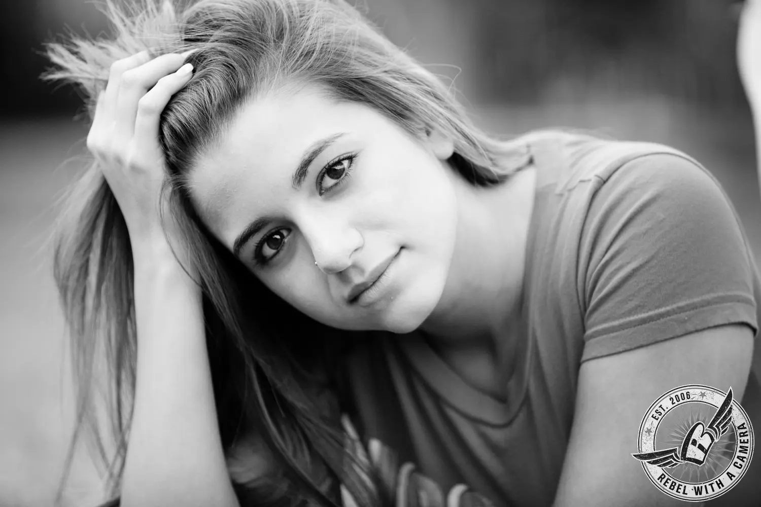 Black-and-white close-up portrait of Ruby resting her head against one hand and looking toward the camera.